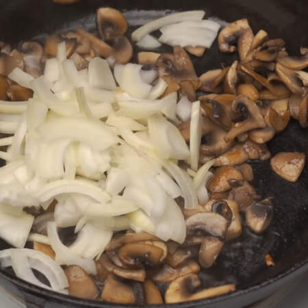 В сковороду с грибами наливаем еще немного подсолнечного масла и кладем порезанный лук.
Все жарим до готовности лука.