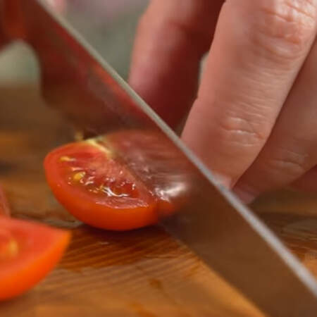 Сначала подготовим все ингредиенты для салата.
200 г помидоров черри нарезаем четвертинками. Также можно использовать и обычные помидоры.