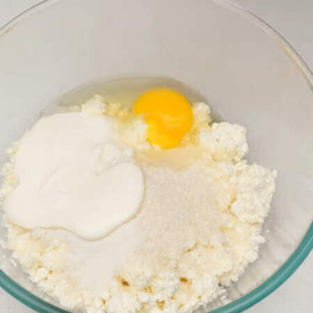 Сначала приготовим начинку. 400 г творога высыпаем в миску. Творог лучше использовать сухой. 
Сюда же добавляем 100 г сахара, 8 г ванильного сахара, 3 ст.л. сметаны и одно яйцо. Все перемешиваем.