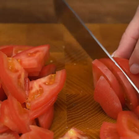 2 помидора разрезаем на 4 части и вырезаем плодоножку. Четвертинки помидоров нарезаем пластинками.
