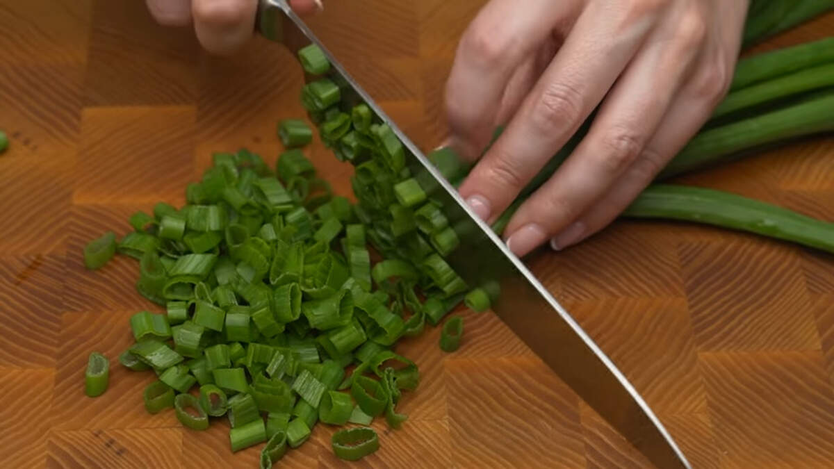 Измельчаем пучок зеленого лука. Вместо зеленого лука можно использовать репчатый лук, нарезав его на полукольцами.