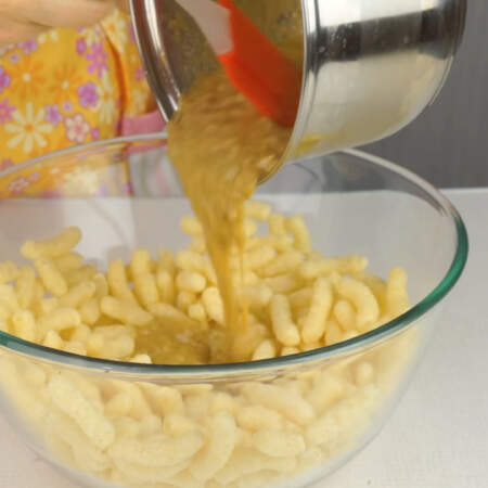 Приготовленный крем выливаем в миску с половиной порции кукурузных палочек.
Немного перемешиваем и сюда же добавляем вторую половину кукурузных палочек.