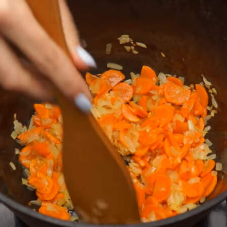 Затем кладем нарезанную морковь. Перемешиваем и пассеруем еще 2-3 минуты. Это блюдо также можно приготовить в большой глубокой сковороде.