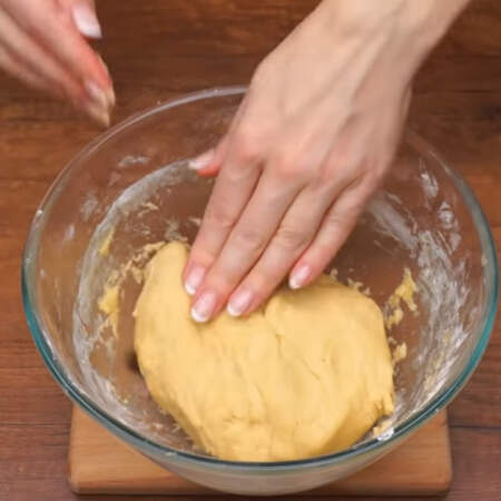 Перемешиваем тесто сначала ложкой, а затем руками. Должно получится мягкое, пластичное и слегка липнущее тесто.