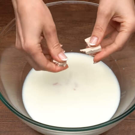 Сначала замесим тесто.
В миску наливаем 300 мл теплого молока. Сюда же насыпаем 100 г сахара, крошим 20 г спиртовых дрожжей и насыпаем 0,5 ч.л. соли. 