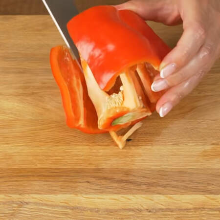Берем один большой сладкий перец и отрезаем у него верхнюю и нижнюю части. Вырезаем семенную коробочку.