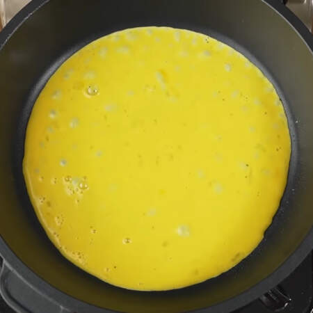 На горячую сковороду, немного смазанную растительным маслом, выливаем часть яичной смеси. 