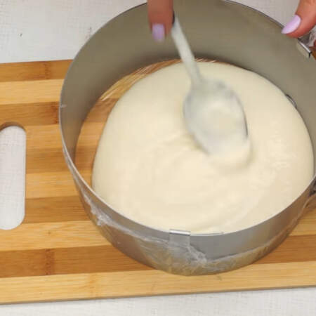 Складываем торт слоями. Сначала на дно наливаем немного творожного крема. На него кладем слой песочного печенья. Всего понадобится примерно 200 г печенья.