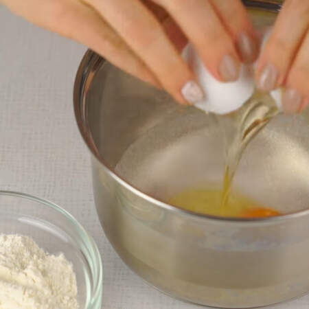 Теперь приготовим заварной крем. В сотейник насыпаем 200 г сахара, ванильный сахар и разбиваем яйцо.