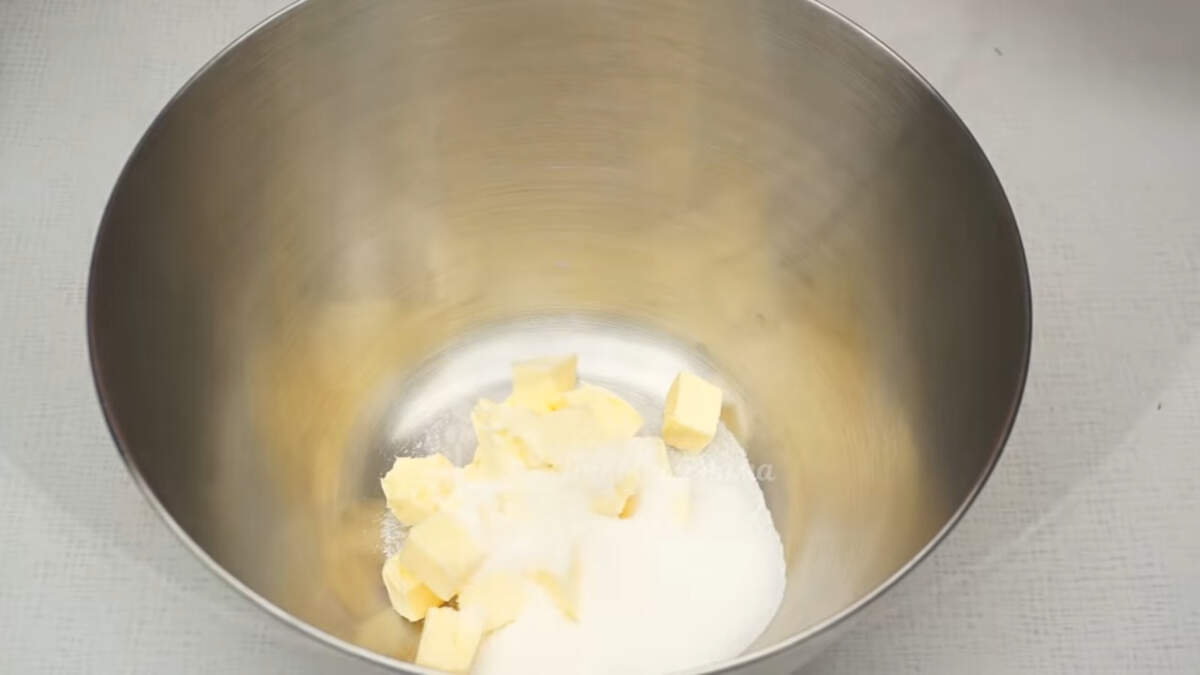 Сначала приготовим песочное тесто.
100 г сливочного масла комнатной температуры кладем в миску. К нему высыпаем 2 ст.л. сахара. Все взбиваем до бела несколько минут.

