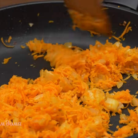 К подзолотившемуся луку добавляем тертую морковь и пассеруем еще примерно 2 минуты.