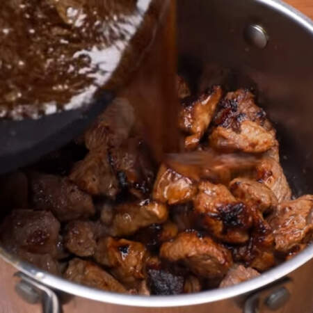 Этой жидкостью смываем пригоревшие остатки мяса со сковороды. Выливаем ее к мясу.