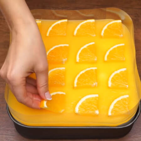 Четвертинки апельсина выкладываем на полностью застывший торт. Выкладываем так, чтоб при нарезке получились квадратные порционные кусочки.