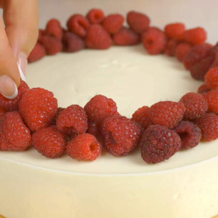 Украшаем торт ягодами малины. 