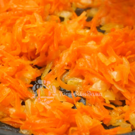 Когда лук уже подзолотится, добавляем тертую морковь. Все жарим до мягкости морковки.