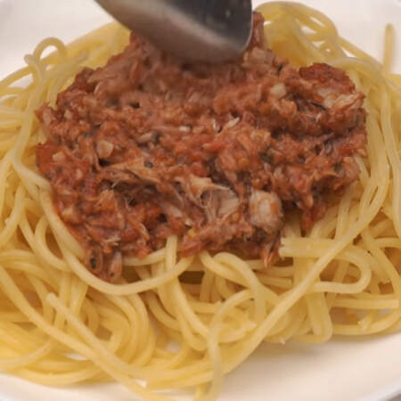 Готовые еще горячие макароны подаем на порционной тарелке и сверху кладем томатный соус с тунцом.