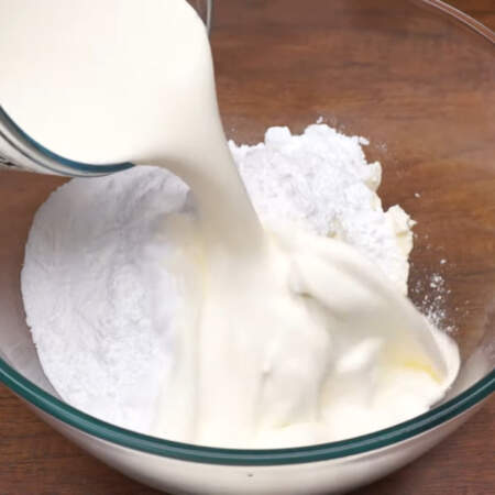 В миску кладем 600 г холодного сливочного сыра. К нему насыпаем 250 г сахарной пудры и наливаем 300 мл холодных сливок жирностью 33%. 