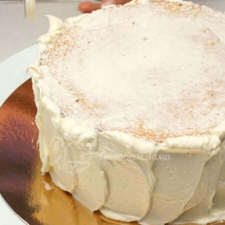 Сразу же, поверх грунтовочного слоя на бока торта накладываем основой слой крема.