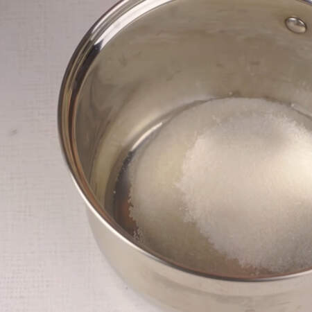 Приготовим белково-заварной крем. В сотейник наливаем 40 мл воды, добавляем щепотку лимонной кислоты и сюда же высыпаем 130 г сахара. 