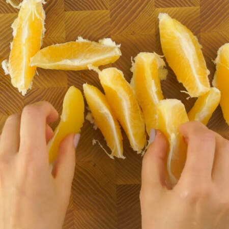 Один апельсин чистим от кожуры и разделяем на дольки.