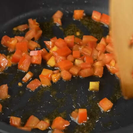 На горячую сковороду с небольшим количеством растительного масла кладем нарезанные помидоры. Обжариваем их 2-3 минуты до мягкости, периодически перемешивая.