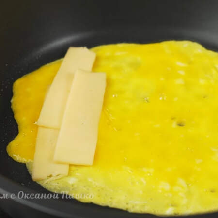Сразу же с одной стороны кладем нарезанные кусочки сыра. 