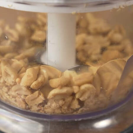 Для начинки понадобится арахис. Насыпаем 100 г жареного соленого арахиса в измельчитель. 