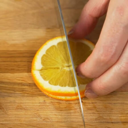 Десерт застыл. Готовим украшение.  Берем апельсин и отрезаем два тонких кружочка. Кружочки разрезаем на 4 части.