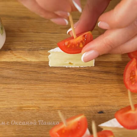 Складываем канапе.
Берем кусочек сыра, на него кладем четвертинку помидора. Все прокалываем зубочисткой. Так готовим все канапе. Из одной головки сыра камамбер получается 12 или 16 канапе, в зависимости от того, на сколько кусочков вы разрежете сыр.

