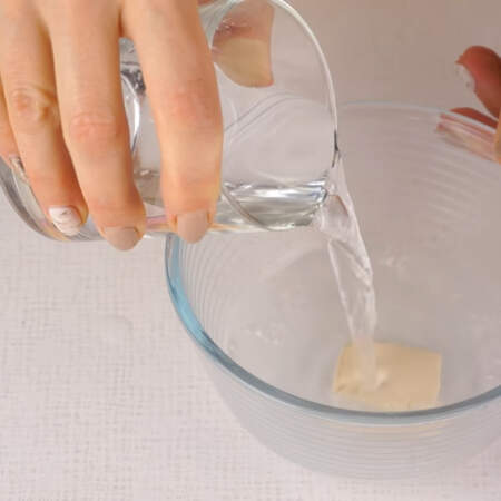 Сначала замесим тесто. В миску кладем дрожжи, насыпаем соль и наливаем пол стакана теплой воды. 