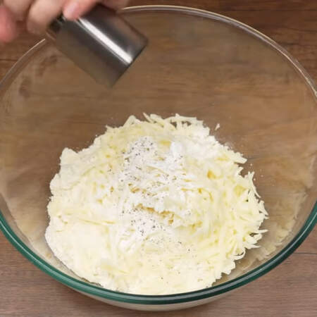 В миску высыпаем крошку и муки и масла, добавляем тертый сыр и насыпаем 2 ч.л. разрыхлителя. Все немного солим и перчим. 