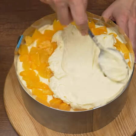  И точно также наносим крем, затем кладем персики и снова крем.
Примерно четвертую часть крема нужно оставить для выравнивания и украшения торта.
