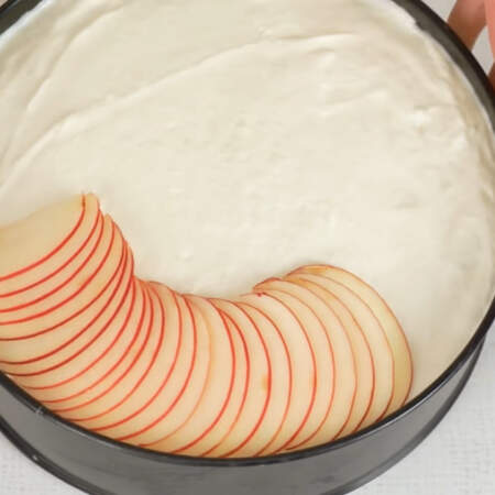 Нарезанные яблоки сразу же выкладываем на застывший торт, чтобы они не потемнели. Яблоки выкладываем по кругу внахлест друг на друга, стараясь придерживаться одинакового расстояния. 