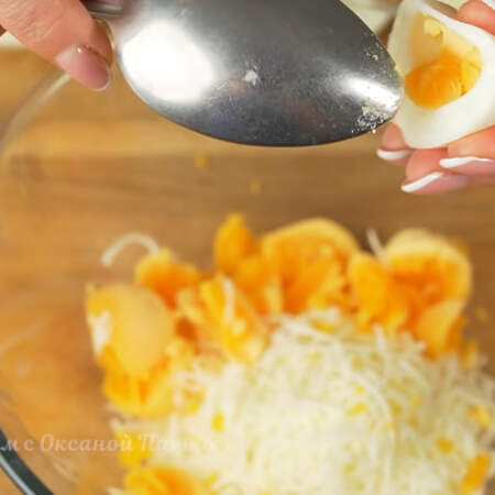 Яичные желтки аккуратно вынимаем в миску к тертому сыру.