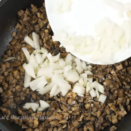 Когда испарится жидкость, наливаем в сковороду к грибам растительное масло. Сюда же кладем нарезанный лук.