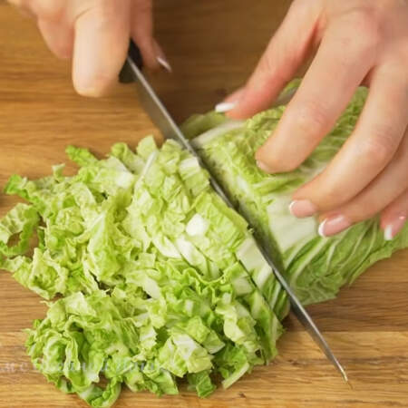 Готовим остальные ингредиенты для салата.
Пол кочана небольшой пекинской капусты мелко шинкуем ножом. Вместо пекинской капусты можно использовать листья салата или смесь салатной зелени.
