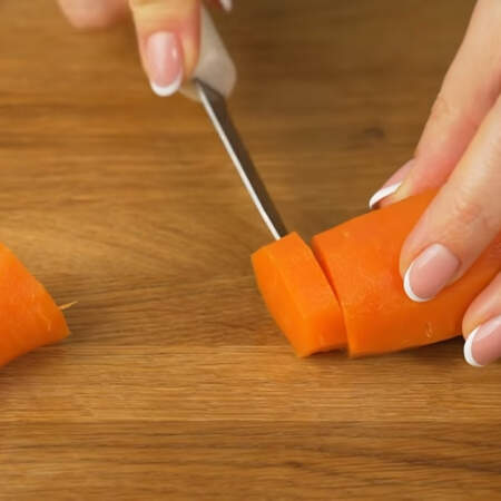 Берем 2 средних вареных морковки и у одной из них вырезаем кружочек, он понадобится позже для украшения. 