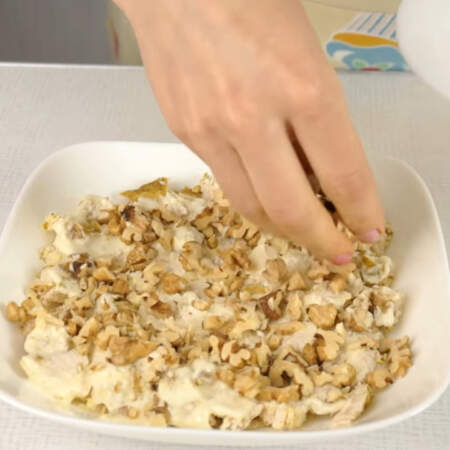 Измельченные орехи выкладываем сверху на мясо.
Также для этого салата можно взять и миндальные орехи, но их обязательно нужно обжарить.