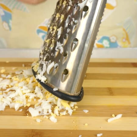 Яйца трем на крупной терке и выкладываем на сырный слой.