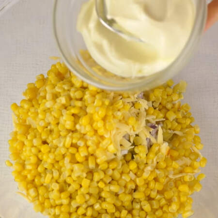 В миску выкладываем нарезанные яйца, лук, огурцы и тертый сыр и банку консервированной кукурузы. Предварительно жидкость с кукурузы сливаем.