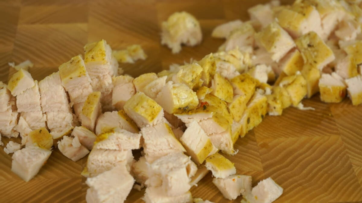 Запеченное или отварное куриное филе нарезаем мелким кубиком.