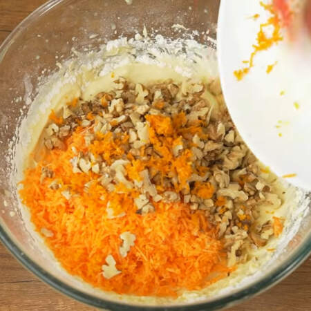 В получившееся тесто насыпаем тертую морковь, измельченные орехи и цедру апельсина. 
