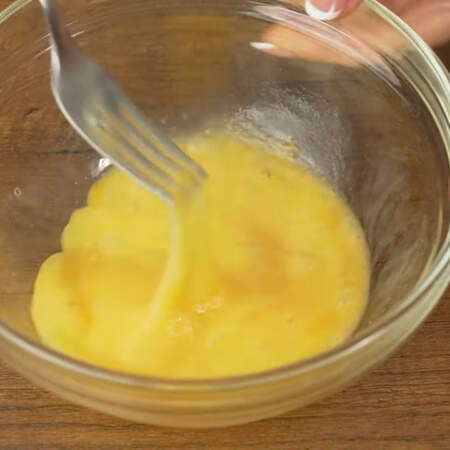 В миску разбиваем 2 яйца и взбиваем их вилкой до легкой пены.
