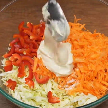 В миску кладем подготовленную капусту, перец, колбасу и тертую морковь. Солим по вкусу и заправляем 2 ст.л. майонеза. 