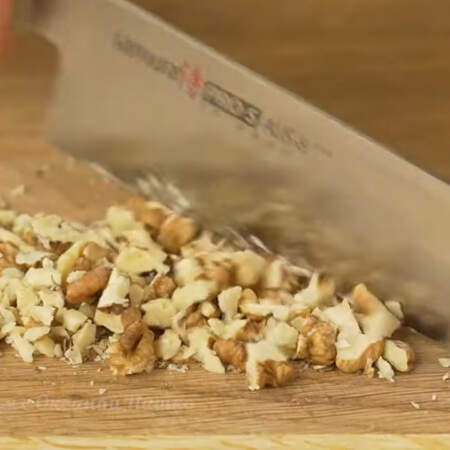 Два-три грецких ореха мелко нарезаем ножом.