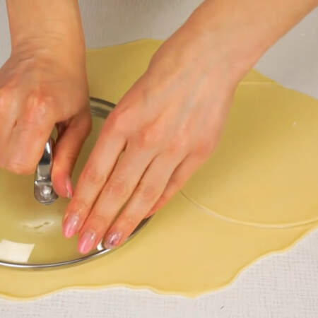 Для вырезания я использую крышку от кастрюли с бортиками, которые легко прорезают тесто. Если такой крышки нет, то можно вырезать тесто с помощью любой крышки нужного размера и ножа. 