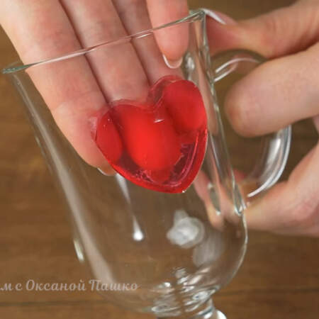Берем стаканы для десерта и с внутренней стороны приклеиваем сердечки из желе. Я наклеиваю по два сердечка с противоположных сторон, но по желанию можно наклеить и больше.
