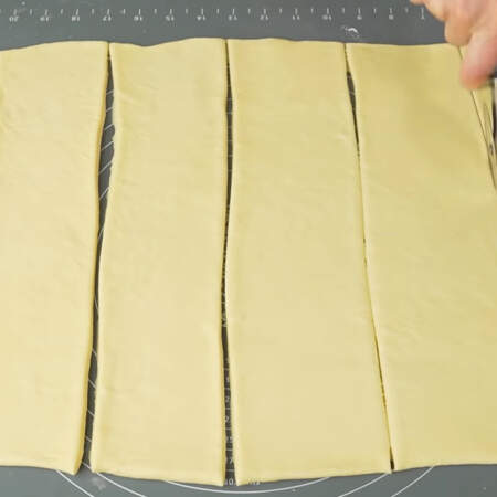 Раскатанное тесто делим на полоски шириной примерно 8-10 см.