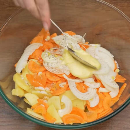 В миску кладем подготовленный картофель, морковь и лук. Все солим по вкусу и перчим. Сюда же добавляем 1-2 ст. л. майонеза или сметаны. 