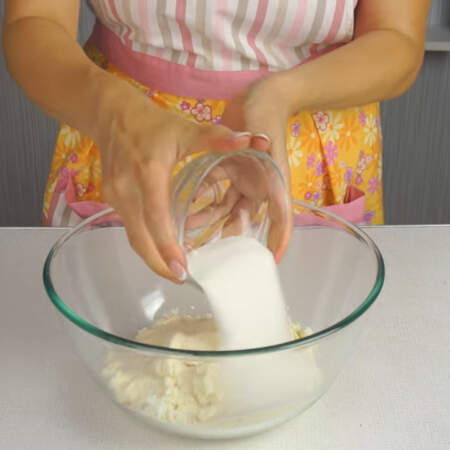 Сначала приготовим тесто для сырников.
В миску насыпаем творог, к нему добавляем манку и сахар. 